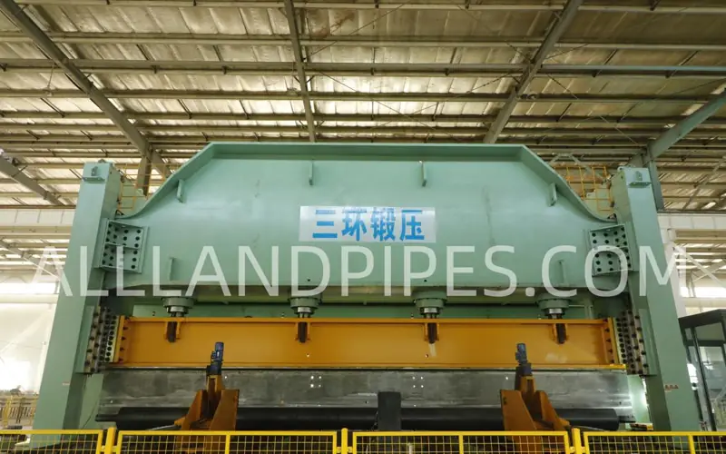 Front view of a large JCOE forming press inside a factory, used for bending steel plates in the LSAW pipe manufacturing process.banner