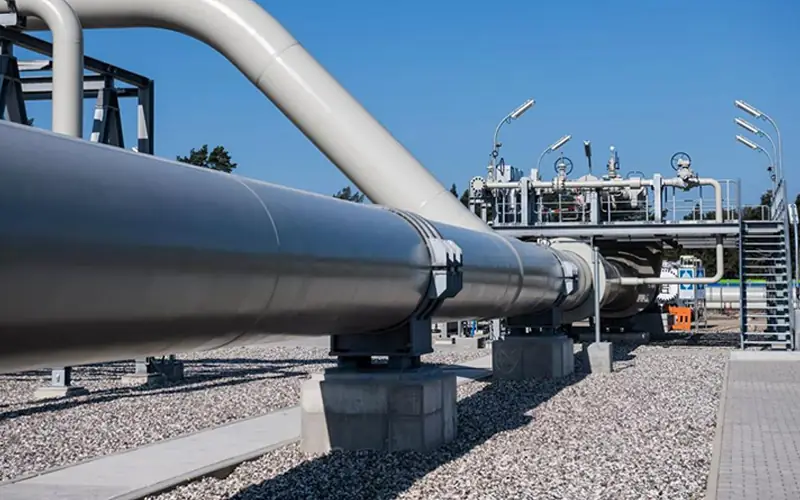Large-diameter offshore line pipe supported on concrete pillars at an onshore processing facility, connecting the subsea network to land.-banner