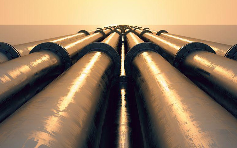 A long-distance array of large-diameter LSAW steel pipes extending towards the horizon under a setting sun, symbolizing efficient oil and gas transportation.