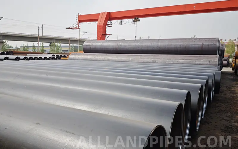 A stockyard of large-diameter black LSAW and SSAW pipes, showing the raw material for a buyer's pros and cons analysis.-banner