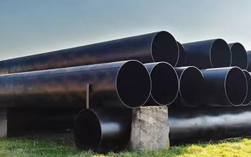 Large diameter heavy wall LSAW steel pipes with black anti-corrosion coating stacked in storage yard, ready for mining slurry pipeline projects.