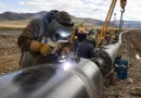 Field welding of large-diameter LSAW steel pipe during long-distance pipeline construction with alignment clamps and girth weld preparation banner