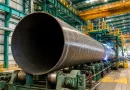 Heavy-wall ASTM A252 LSAW steel pipe piles being manufactured in an industrial factory, showing JCOE forming, submerged arc welding, and offshore foundation pipe production line for marine engineering projects banner.