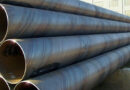A stack of large-diameter SSAW (spiral submerged arc welded) steel pipes with visible spiral seams, ready for a long-distance water transmission project.-banner