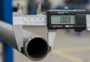 A close-up of a digital caliper precisely measuring the Outer Diameter (OD) of an Allland steel pipe, highlighting the exact physical dimension crucial for procurement.